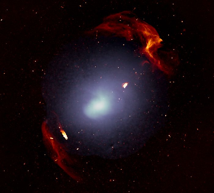 The massive galaxy cluster Abell 3667. Individual galaxies are too small to be distinguished in this image. The white smooth colour shows the distribution of the gas that permeates the space within the galaxies of this galaxy cluster. The red structures trace the two big shock waves that were generated during the formation of the galaxy cluster. Image credit: Francesco de Gasperin, SARAO