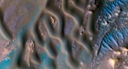 Though Mars is the Red Planet, false-color images can help us learn about its weather and geology. This image shows a variety of wind-related features on the Red Planet near the center of Gamboa Crater. Larger sand dunes form sinuous crests and individual domes.