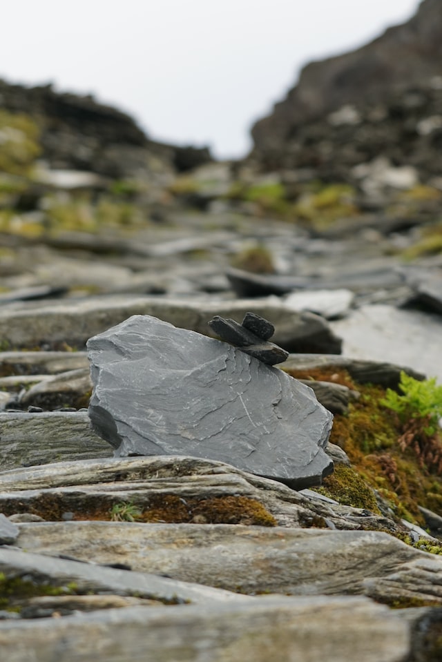A slab of natural graphite visible over other graphite slabs. Photo by Martin Turgoose on Unsplash
