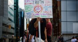 A person holding up a handwritten poster with lots of writing on it in different colours. The main text says Poster of Truth. By Tom Carnegie on Unsplash