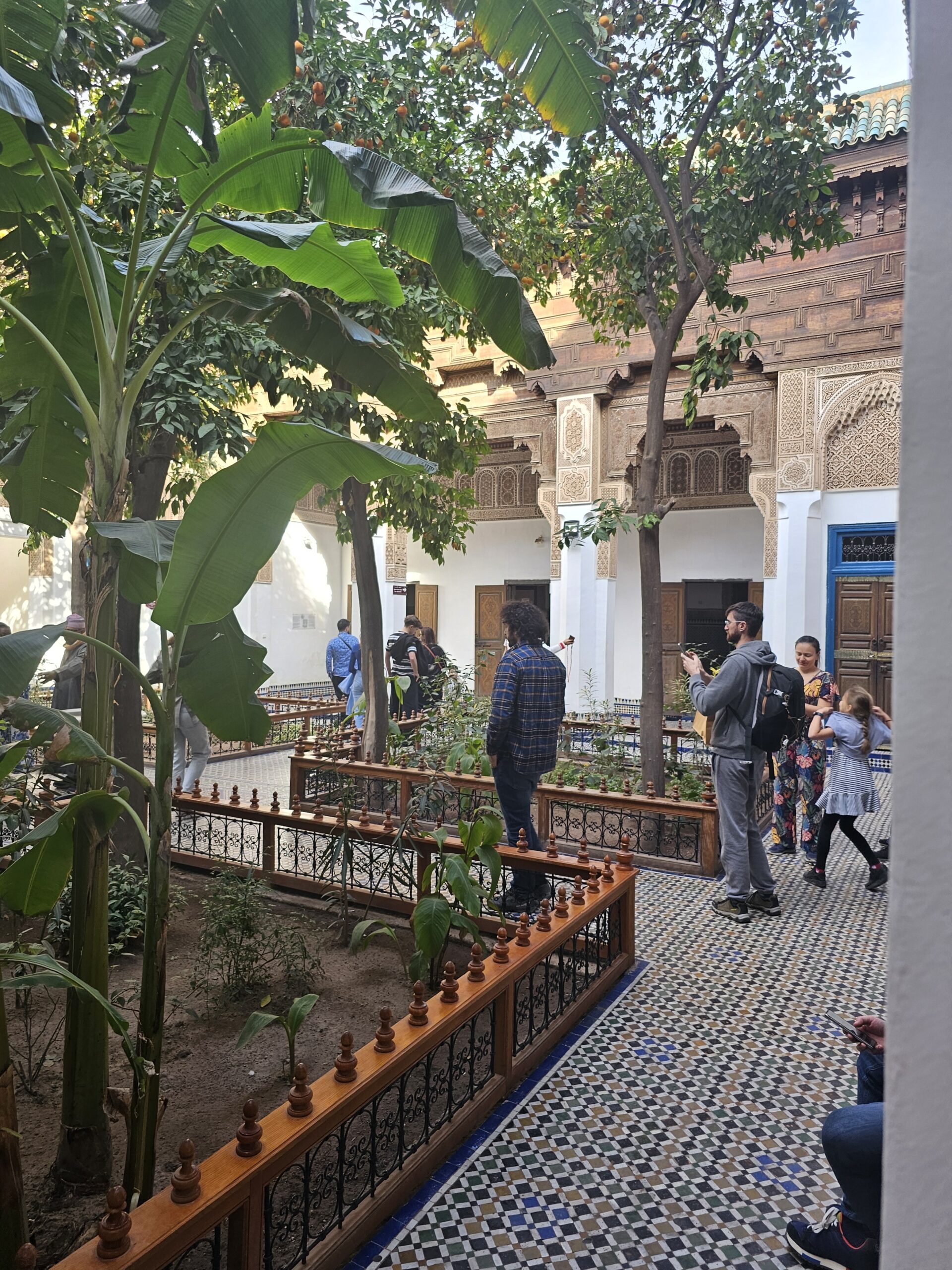 Courtyard of Bahia Palace. Image by 360onhistory showing people walking around the plant beds that have trees.
