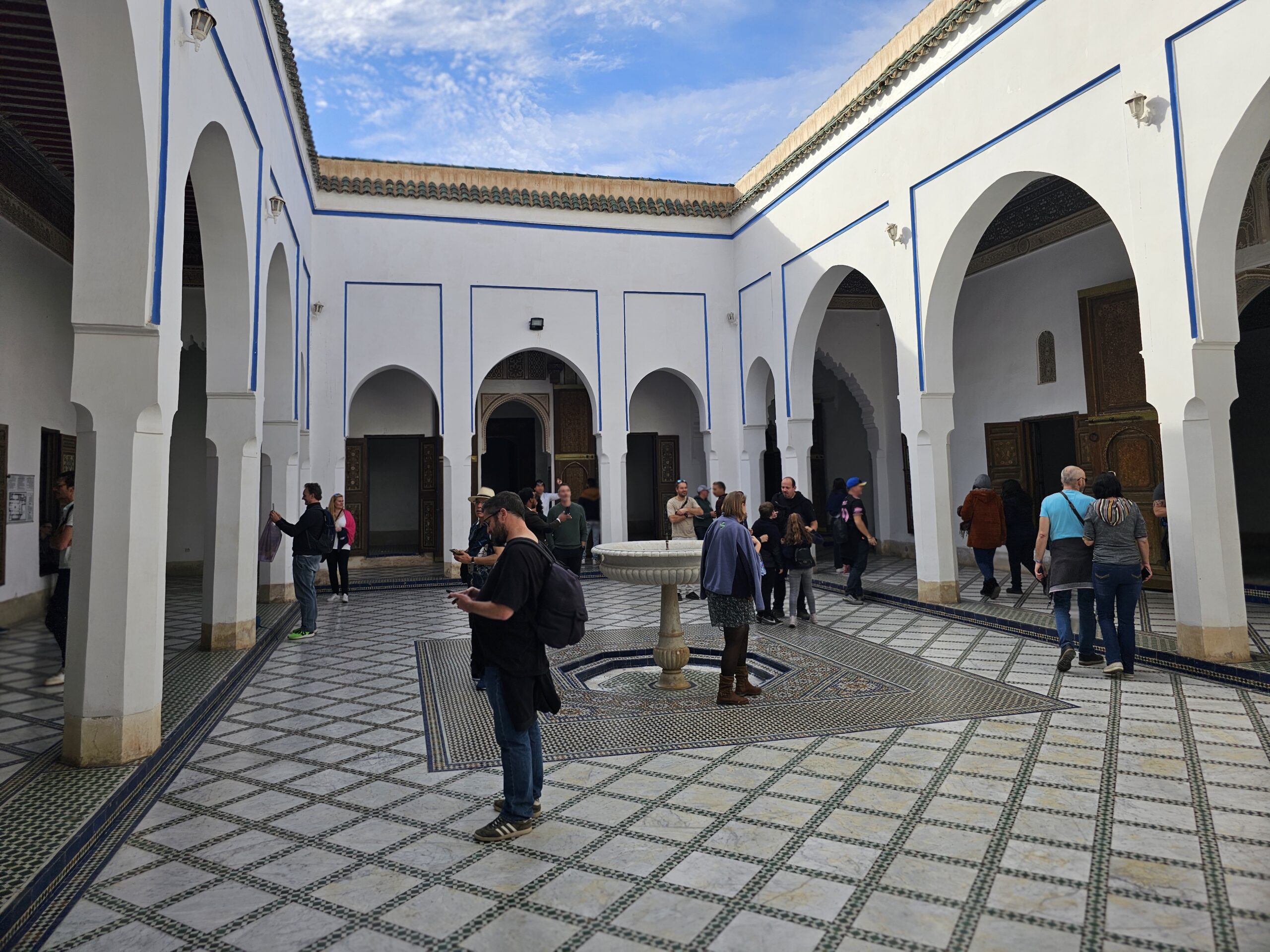 A smaller courtyard at Bahia Palace, Marrakesh, with people milling around. Image by 360onhistory.com
