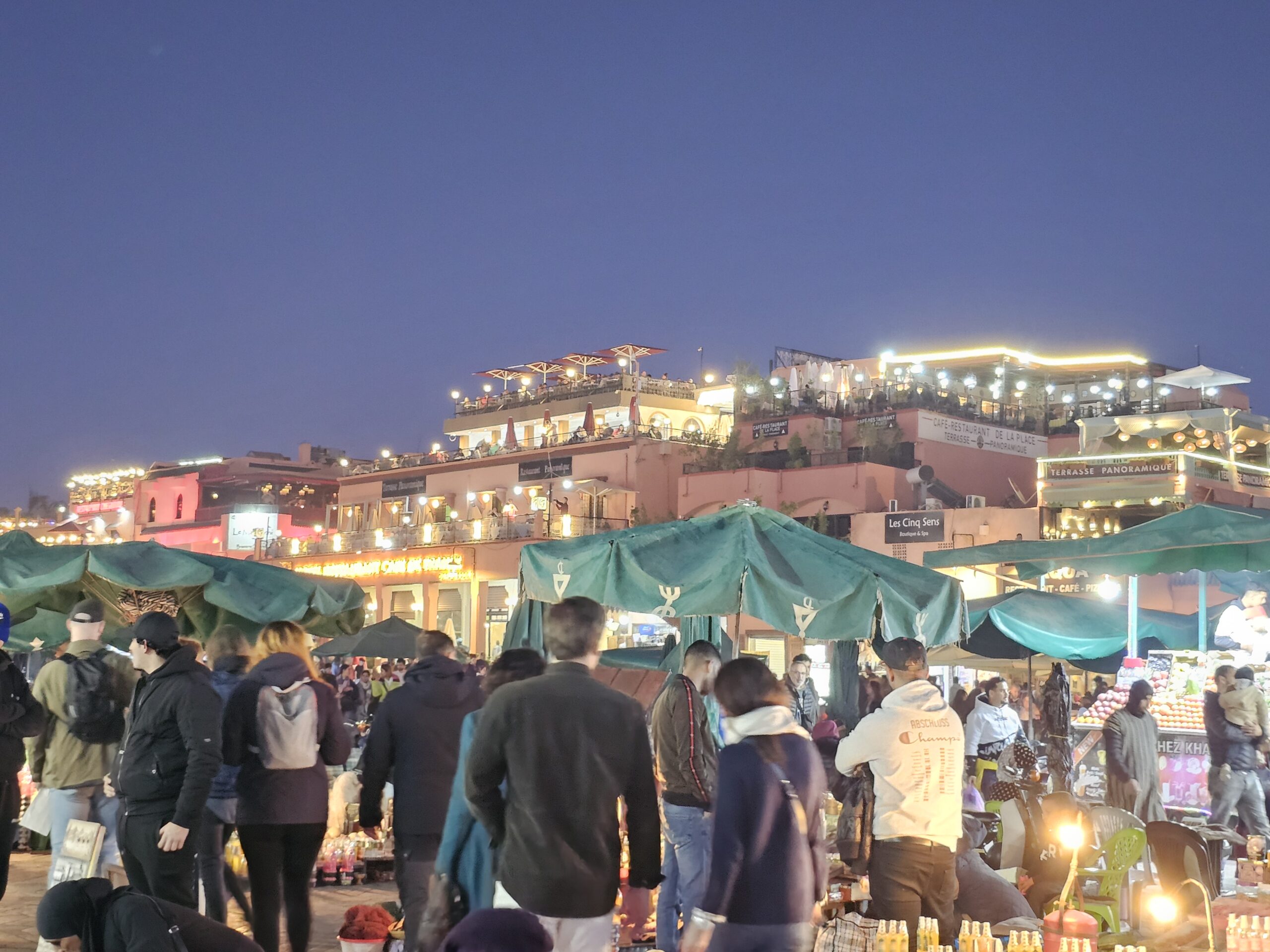 People bustling around at Jemaa el Fnaa at night. Image by 360onhistory.com