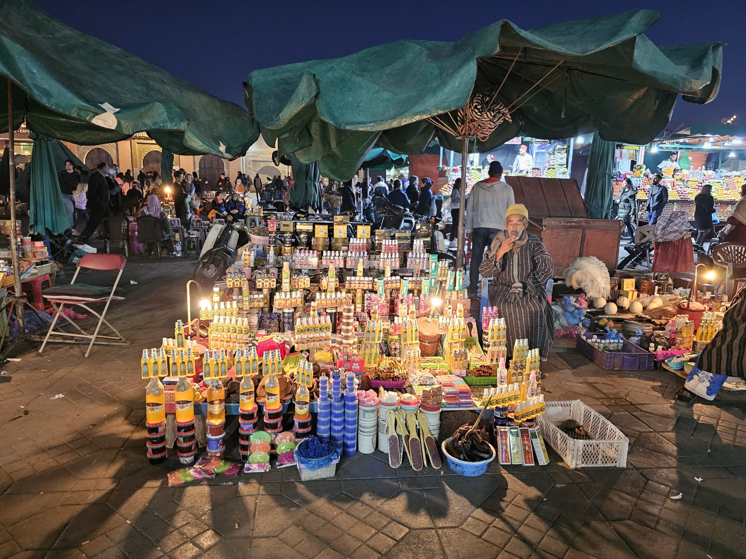 A stall with vender sitting next to it selling Argan Oil, Jemaa El Fnaa, Marrakesh. Image by 360onhistory.com