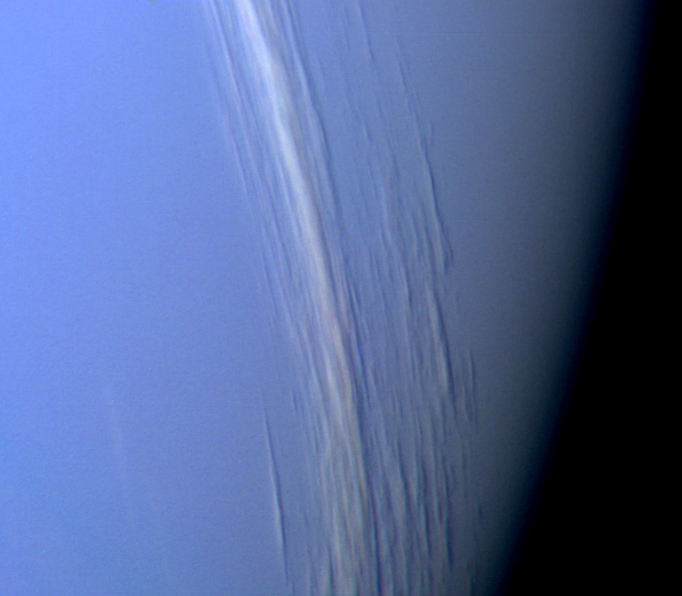 Bands of high-altitude clouds cast shadows on Neptune's lower cloud deck. The colour is exaggerated to show the clouds more clearly.